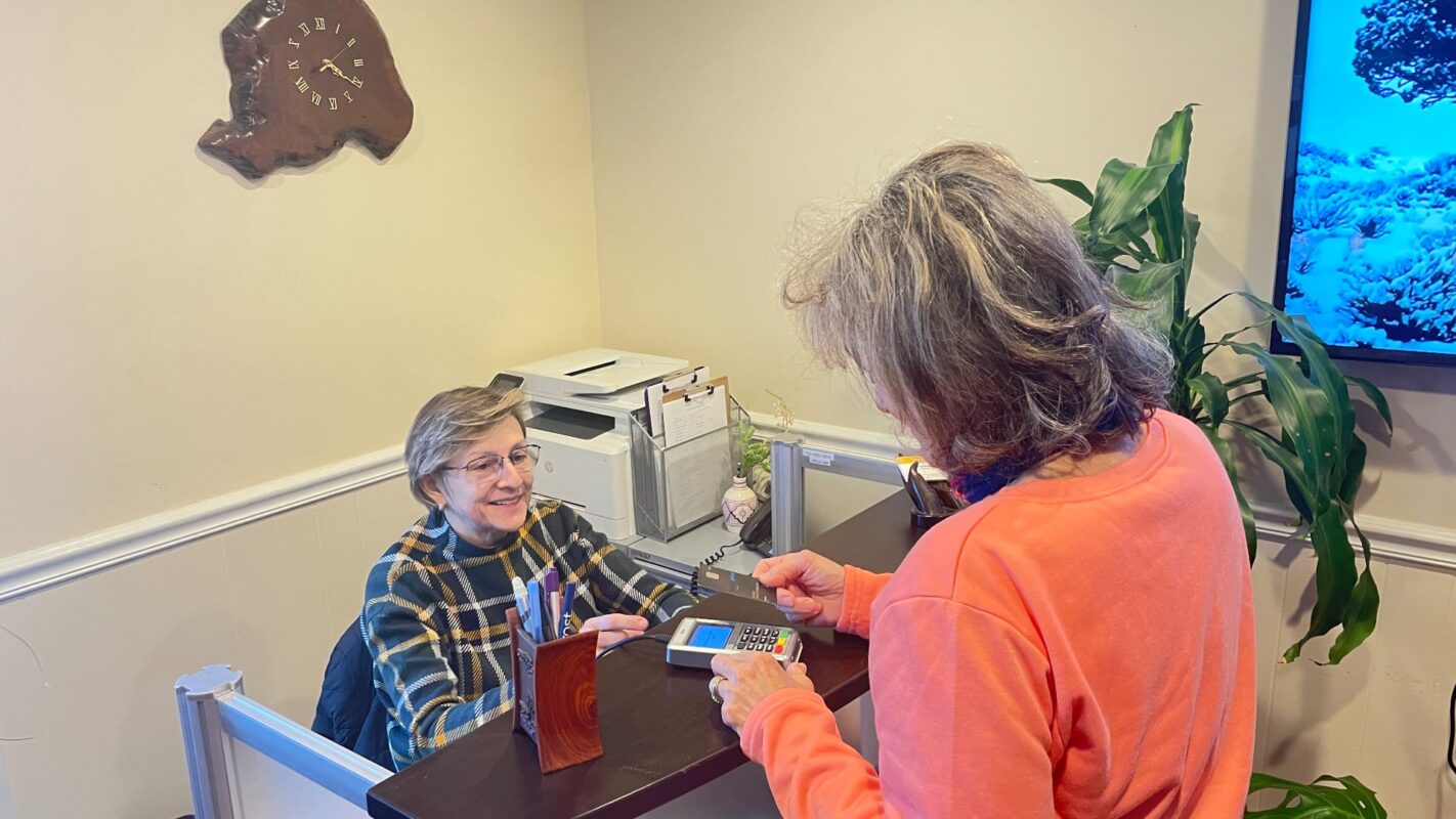 A lady making an appointment at the front desk